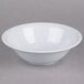 A white Thunder Group Imperial melamine bowl with a white rim on a gray surface.