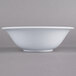 A close-up of a white Thunder Group Imperial melamine bowl with a white rim.