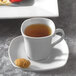 A Bright White square porcelain cup of tea on a saucer.