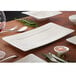 A white Villeroy & Boch Modern Grace rectangular plate with a knife and fork on a table.