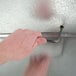 A hand using a key to open a Norlake walk-in freezer door.