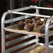 A Regency sheet pan rack with a tray of muffins on it.