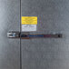 A Norlake Kold Locker outdoor walk-in freezer with a metal door and a lock.