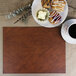 A brown Harley faux leather placemat with a plate of pastries and a cup of coffee.