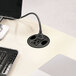 A black cord plugged into the HON AC Power Outlet Hub on a white table.