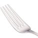 A close-up of a Walco stainless steel table fork with four tines.
