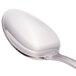 A close-up of a Walco stainless steel demitasse spoon with a silver handle.