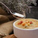 A bowl of soup with a spoon in it.