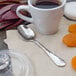 A Walco stainless steel demitasse spoon in a cup of coffee on a table.