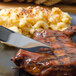 A plate of food with a Walco stainless steel dinner knife and a piece of meat.