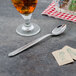 A glass of iced tea next to a Walco Maremma iced tea spoon.