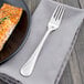 A Walco stainless steel fish fork on a plate of food.