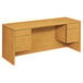 A wooden HON 10500 Series pedestal credenza with drawers and a cabinet.