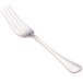 A close-up of a Walco stainless steel table fork with a white handle.