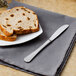 A Walco stainless steel butter knife on a plate with a slice of bread.