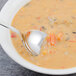 A bowl of bouillon soup with a Walco stainless steel bouillon spoon in it.