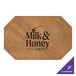 A brown leather H. Risch, Inc. octagon placemat with black customizable text that says "milk and honey cafe"