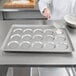 A woman using a Chicago Metallic ePAN to bake muffins.