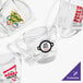 A group of Acopa clear glass coffee cups with a custom red logo.