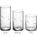 A group of Acopa clear highball glasses with a white liquid in one.