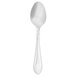 A close-up of a Walco stainless steel demitasse spoon with a white handle.