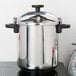 A Monix stainless steel pressure cooker on a stove.