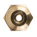 A close-up of a brass hexagon with a circular hole in the middle.