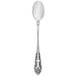 A close-up of a Walco Classic Baroque stainless steel iced tea spoon with a pattern on the handle.