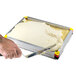 A hand using a knife to cut a white mousse in a Matfer Bourgeat mousse frame.