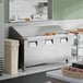A stainless steel, three-door mega top refrigerated sandwich prep table with a raised ingredient rail and cutting board.