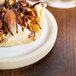 A Chef & Sommelier white stoneware plate with food on a table.