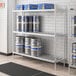 A Regency metal keg rack with several beer kegs on shelves.