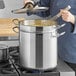 A woman using a Vigor stainless steel double boiler on the stove to stir food.