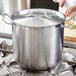 A large silver stainless steel lid on a pot on a stove.