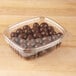 A clear Genpak plastic deli container filled with chocolate candies.