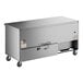 A stainless steel True undercounter refrigerator with wheels.