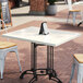 A white Art Marble Furniture Carrera White Quartz table on an outdoor patio.