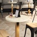 A round white quartz table top on a table in a coffee shop.