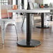 A Lancaster Table & Seating black cast iron table base in a restaurant dining area.