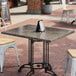 An Art Marble Furniture Storm Gray Quartz Tabletop on a table with chairs on a brick patio.