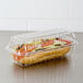 A sandwich in a Dart clear plastic hoagie container with a hinged lid.