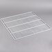 A white coated wire bottom shelf on a gray surface.