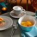 A white plate of fruit and a Villeroy & Boch Terra porcelain coffee cup on a table.