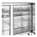 A True 3 door stainless steel refrigerator with shelves inside.