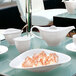 A white table with white dishes and a white Villeroy & Boch creamer on it.