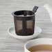 A teapot and cup of tea on a white surface.