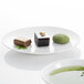 A Villeroy & Boch white bone porcelain plate with a bowl of food and a green tea cup on a white surface.
