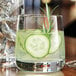 A Chef & Sommelier Sequence rocks glass with cucumber slices in a drink.