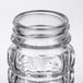 A close up of a clear glass Tablecraft Nostalgia salt and pepper shaker with a stainless steel top.