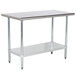 A white rectangular Advance Tabco stainless steel work table with a galvanized undershelf.